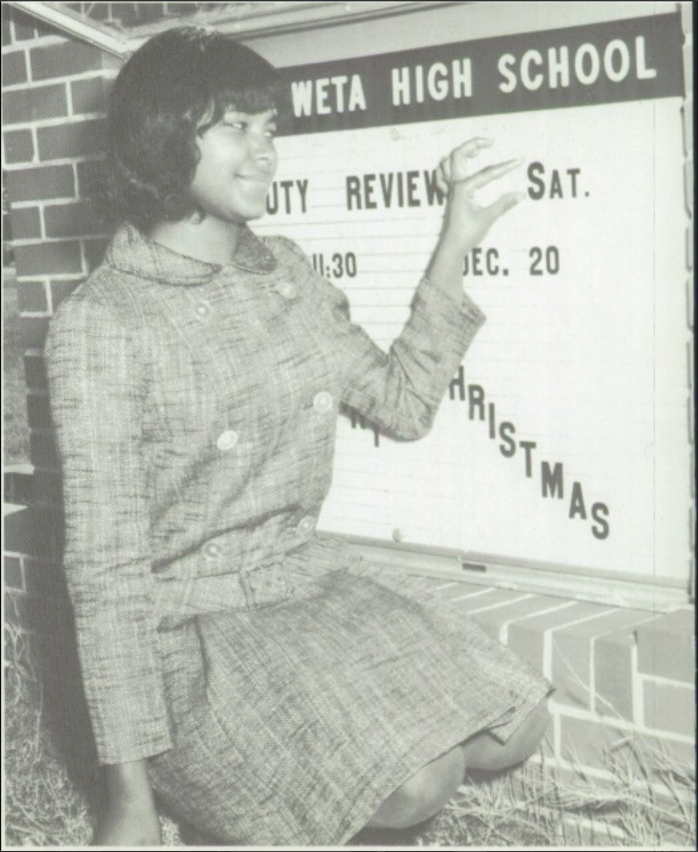 Linda Glanton Early adjusts the sign for the East Coweta High School beauty review