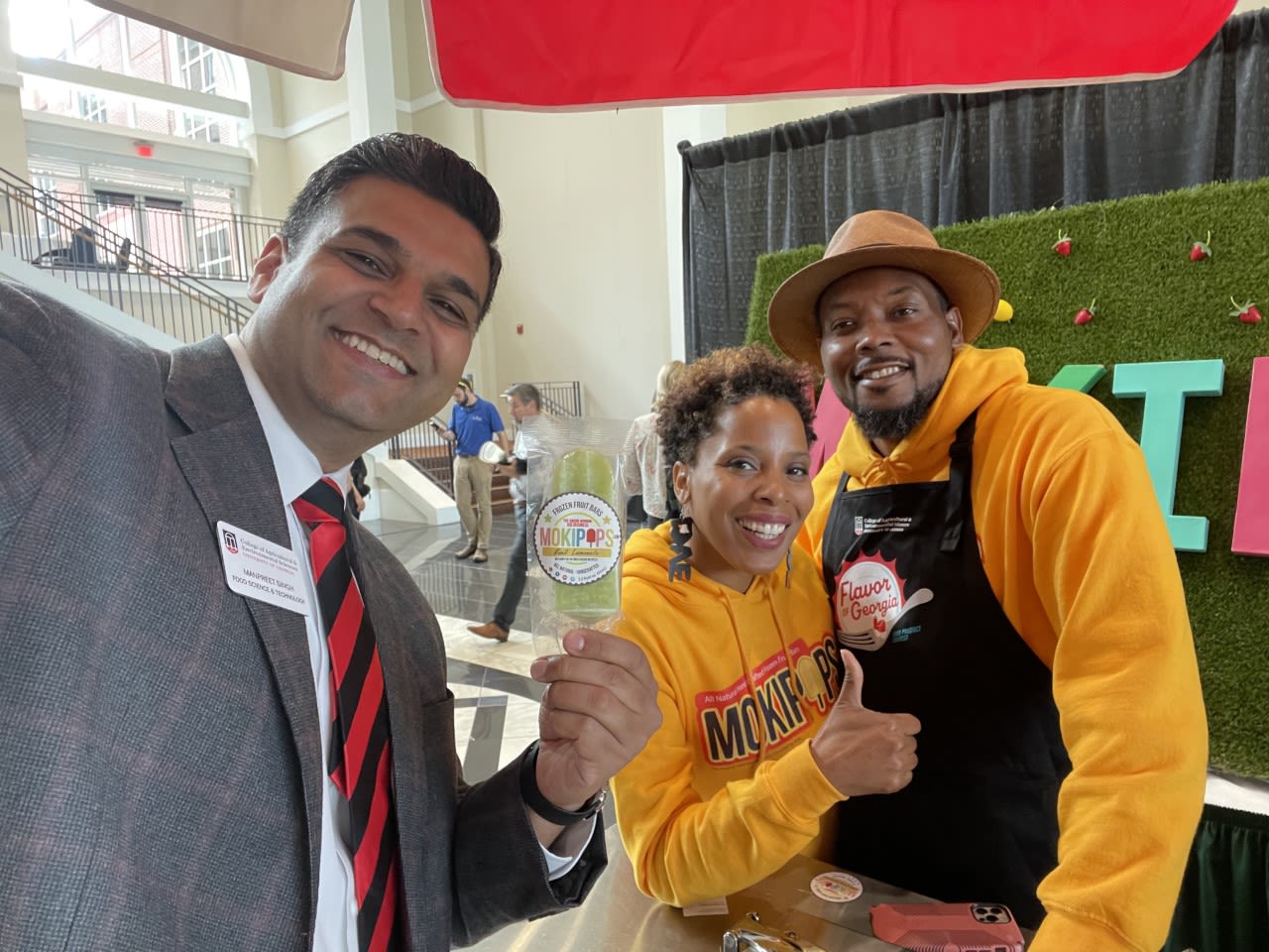 Manpreet Singh poses with the owners of Mokipops at the 2022 Flavor of Georgia event
