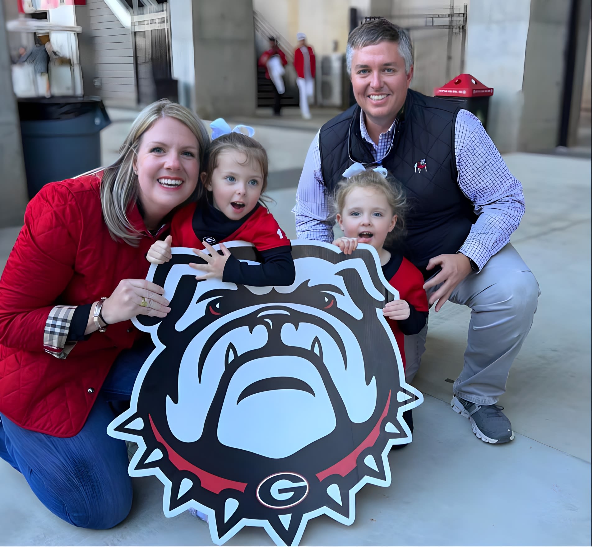 Phil Jennings and his wife and young daughters dressed in UGA gear outside Sanford Stadium