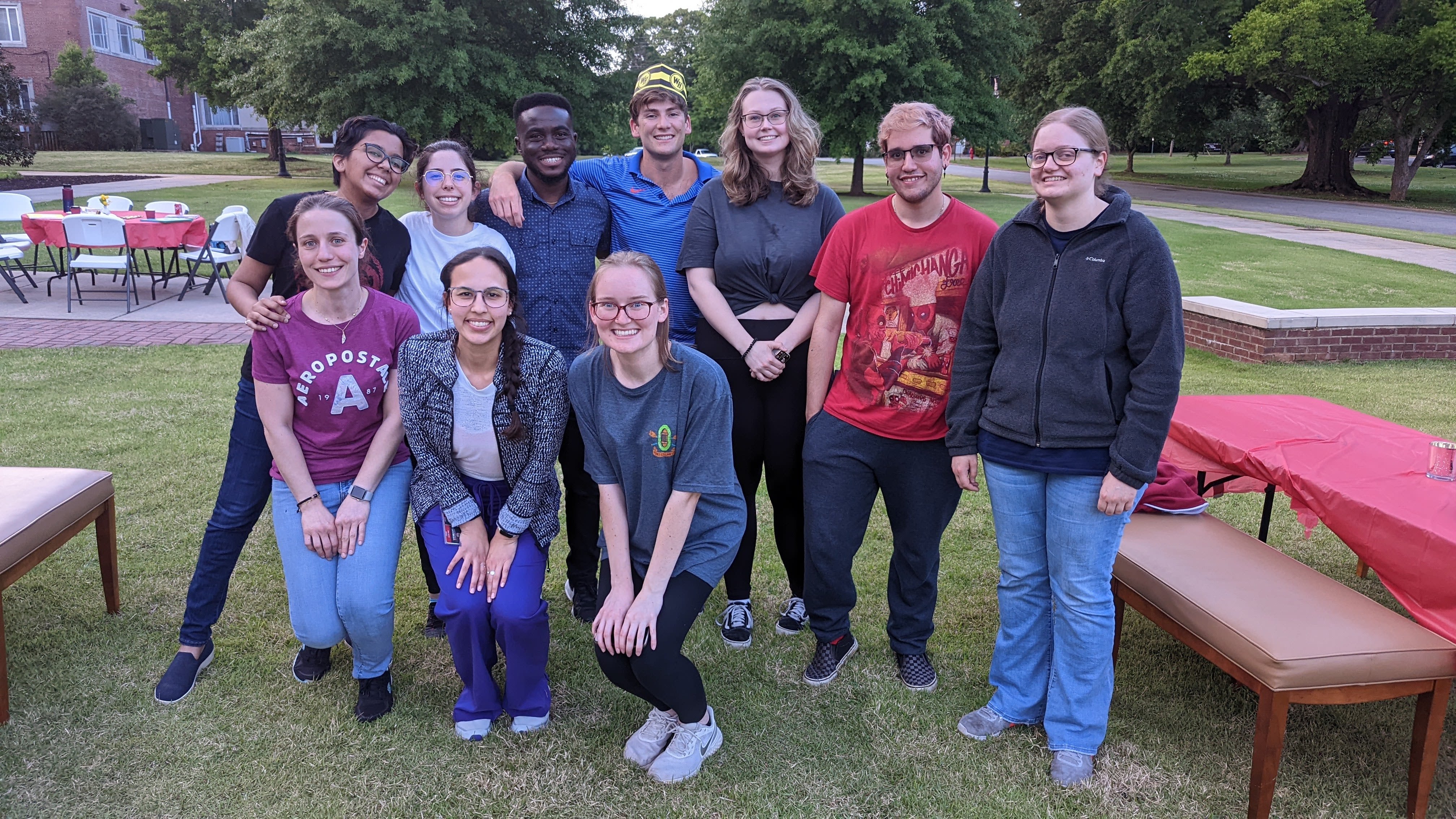 Raad and other students pose near tables they have set up outside on the UGA Griffin campus.