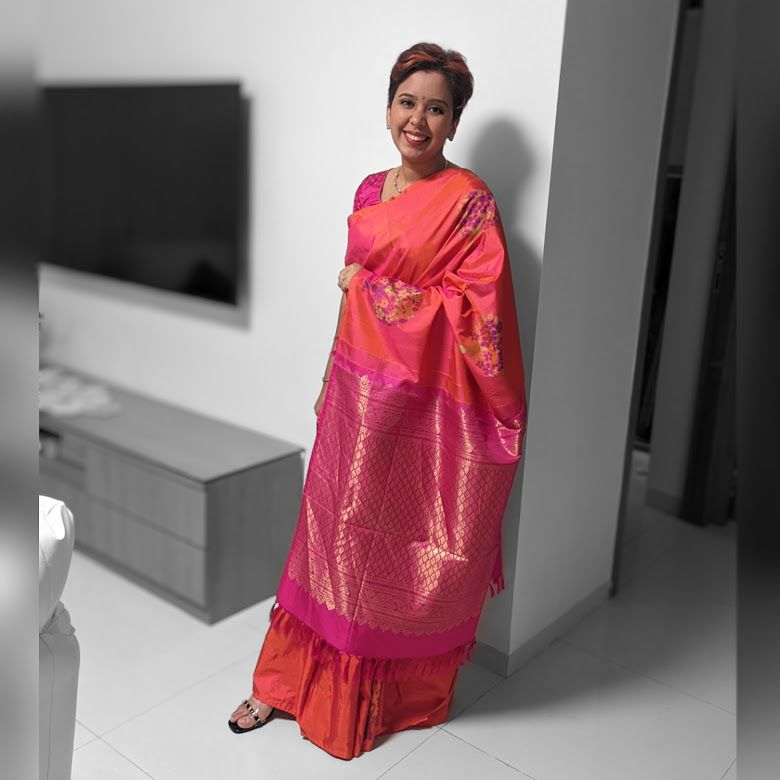 Narwankar wearing a pink and orange sari in a black-and-white home setting
