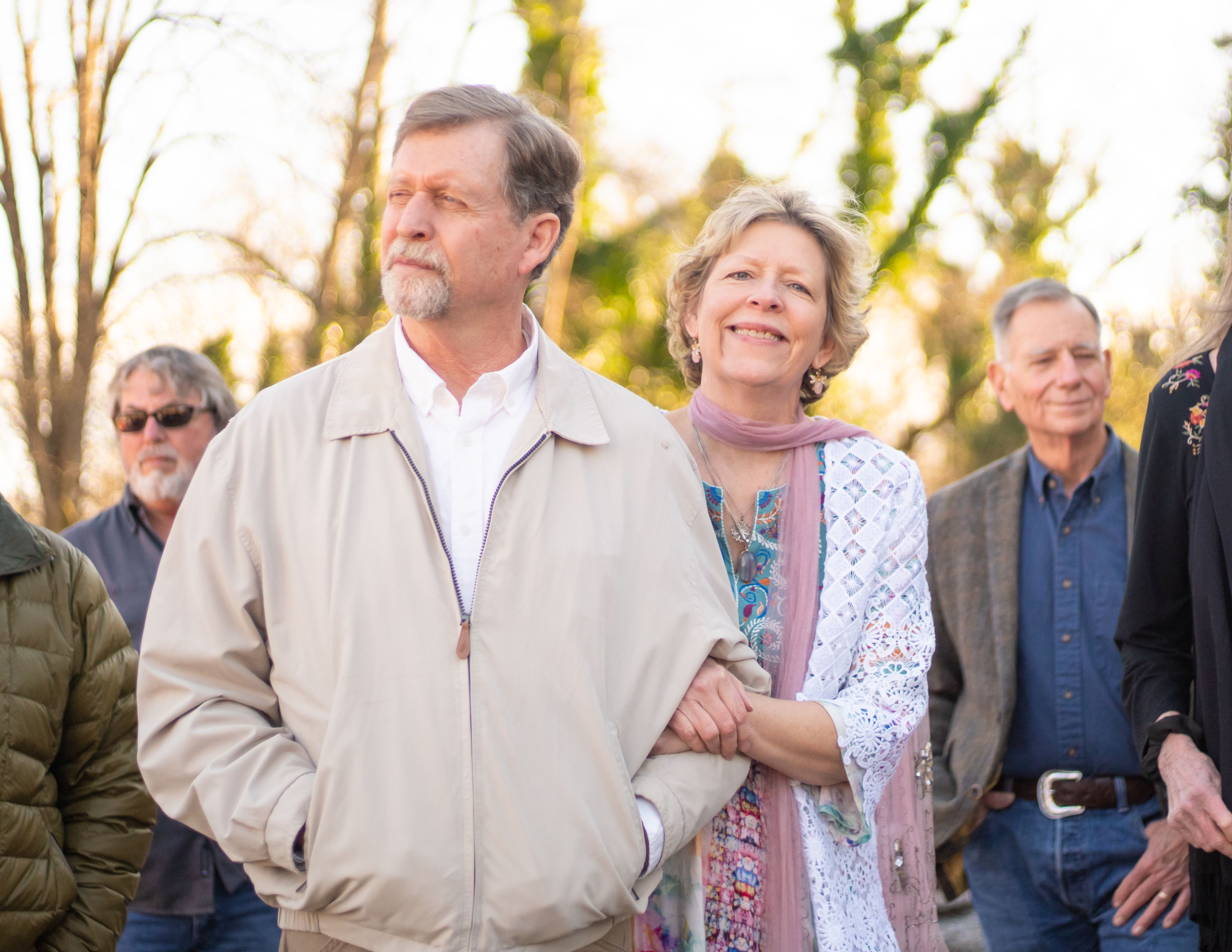 Davis looks into the distance while Berry smiles at the camera during the distillery's ribbon cutting, attended by friends and members of the community