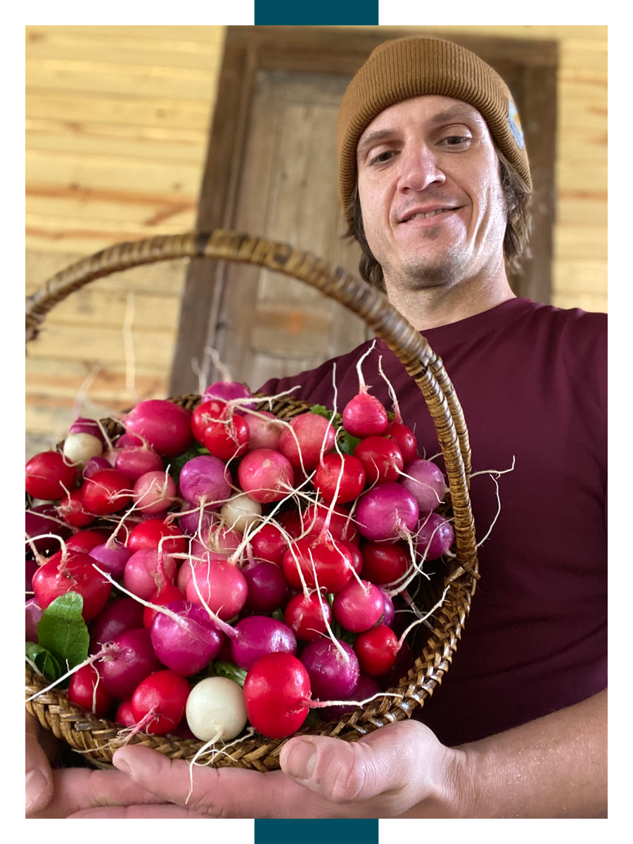 Ty Brooks, director of the UGArden student community farm, smiles while holding a large basket of radishes in hues of red, pink and white.