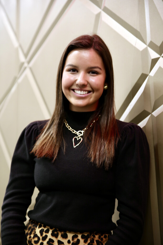 A medium distance image of a woman smiling at the camera.