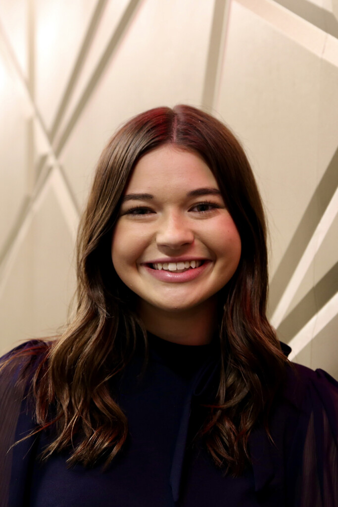A close up image of a woman smiling at the camera.