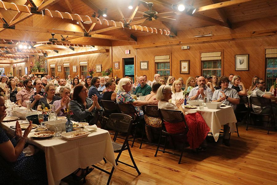 A room with rows of tables at a banquet celebrating UGArden with hundreds of guests clapping.