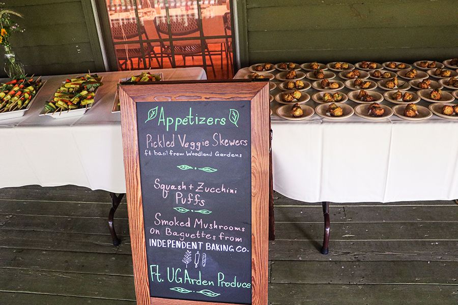 A sandwich board is propped in front of tables of colorful hors devours letting guests know what each appetizer is.