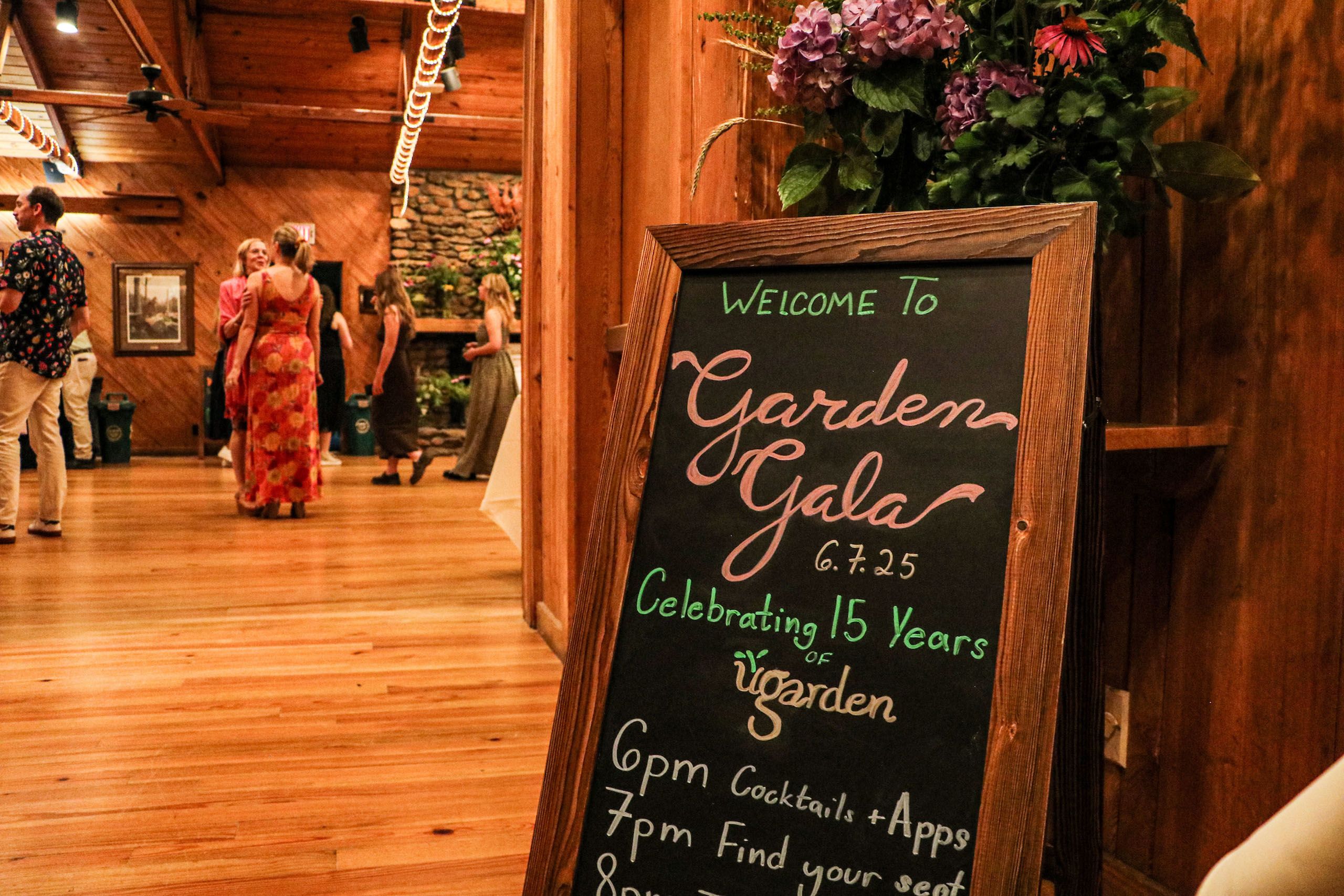 A sandwich board says "Welcome to Garden Gala Celebrating 15 Years of UGArden"