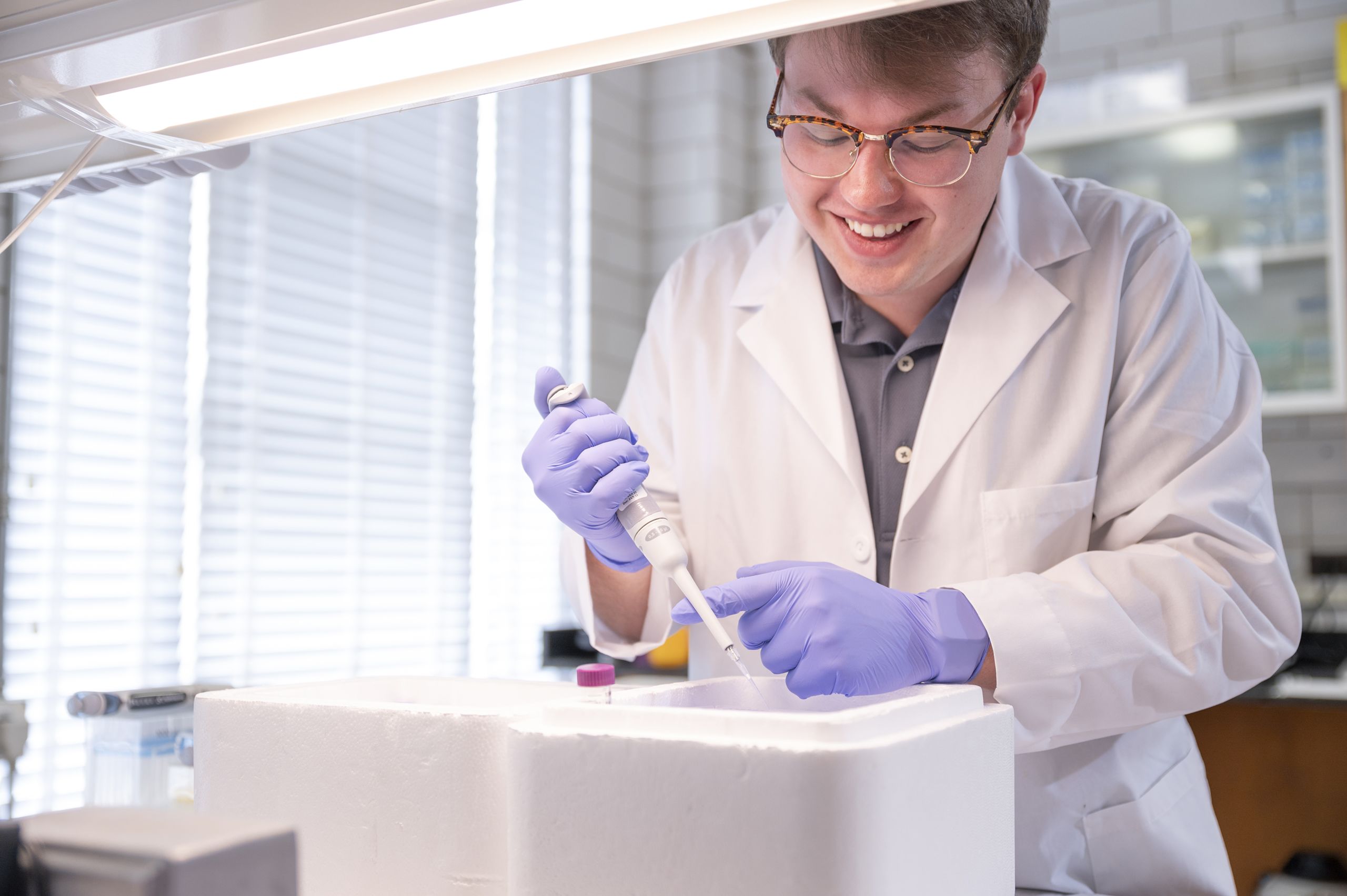 A student using a pipette in a laboratory.
