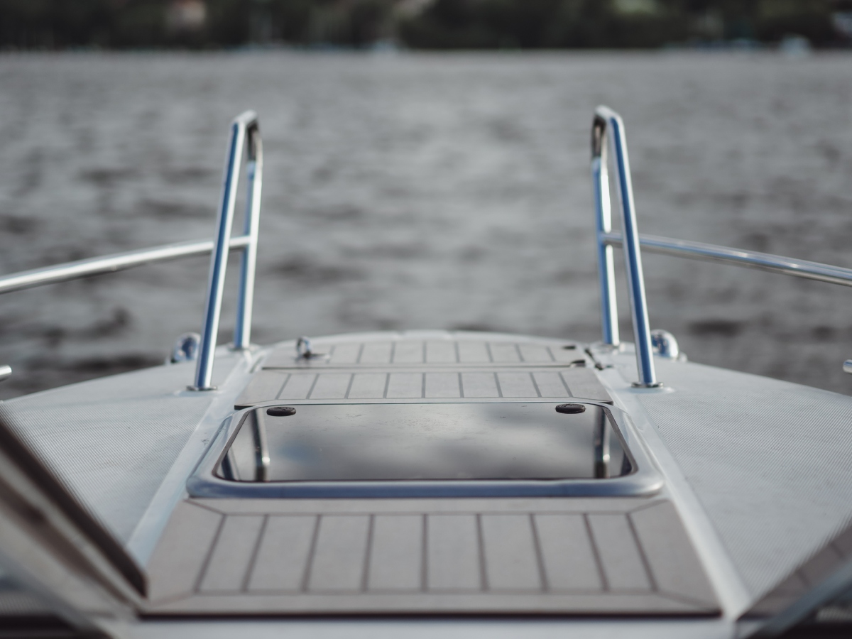 Bow of a boat with a stainless steel ladder for boarding.