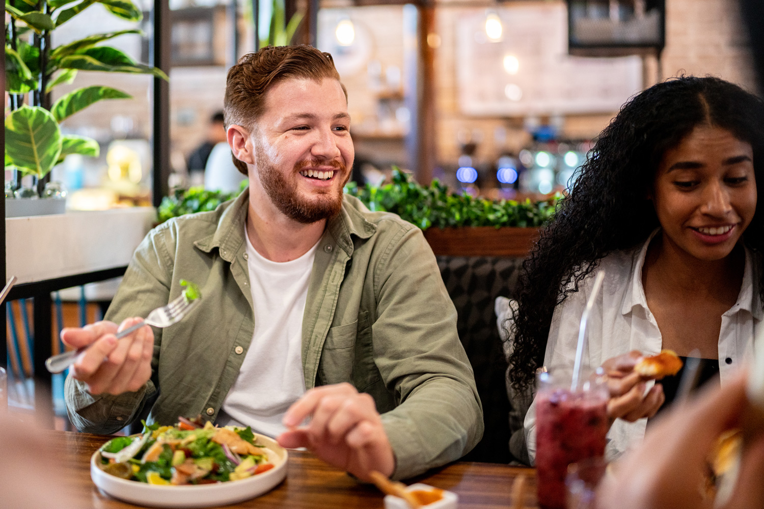 a man and a woman are enjoying a healthy meal at a restaurant