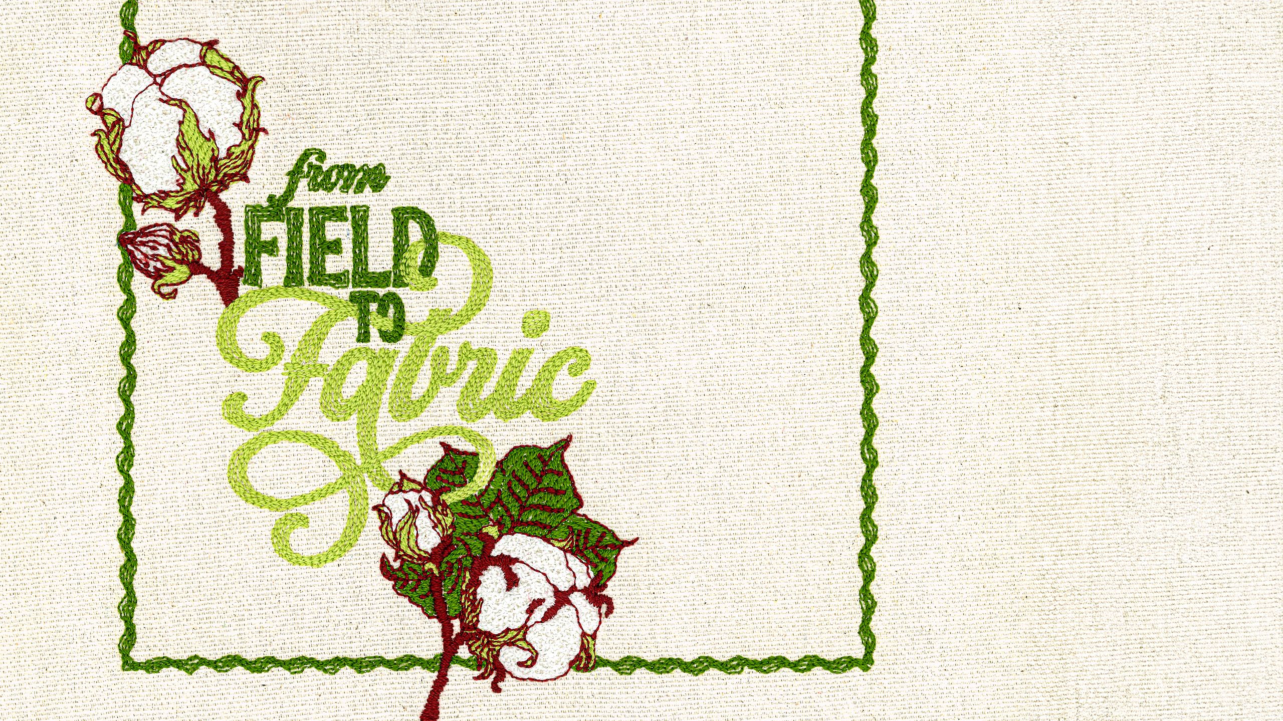 Embroidered cotton fabric with "From Field to Fabric" text and cotton plant illustrations in green and red thread.