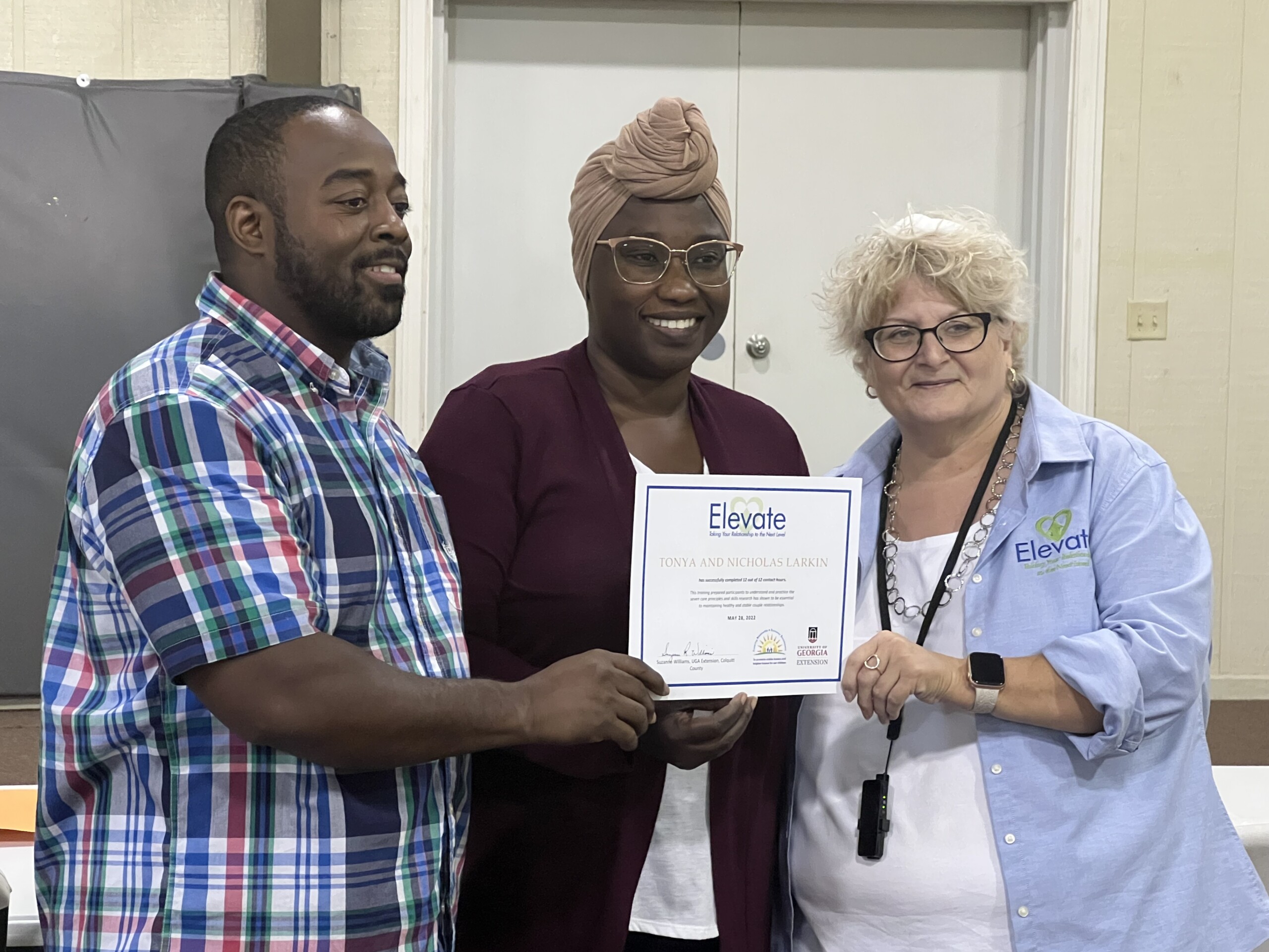 Nicholas and Tonya Larkin hold up an Elevate certificate with their program leader