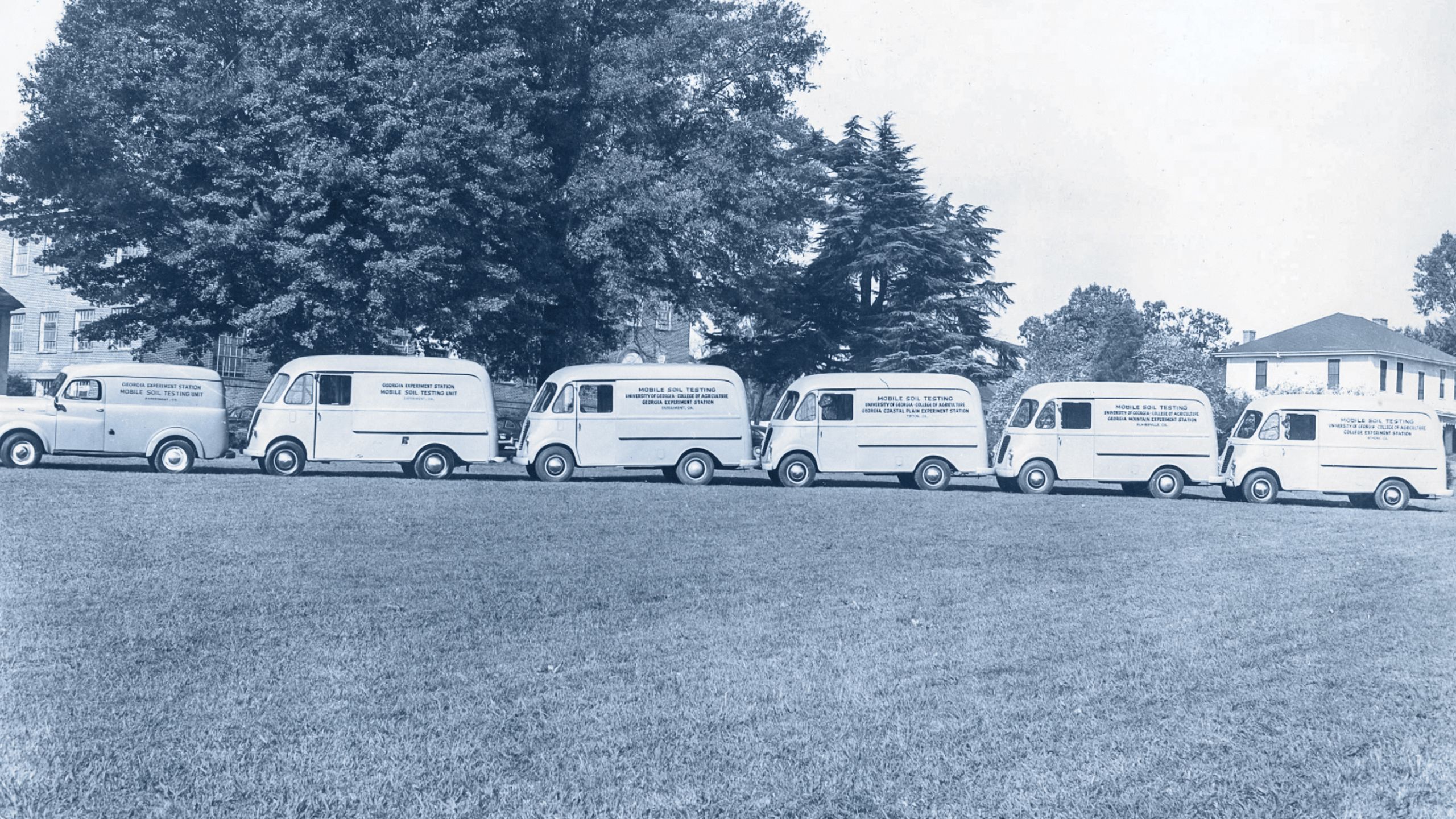 1950s era black and white photo of six soil testing trucks in a row