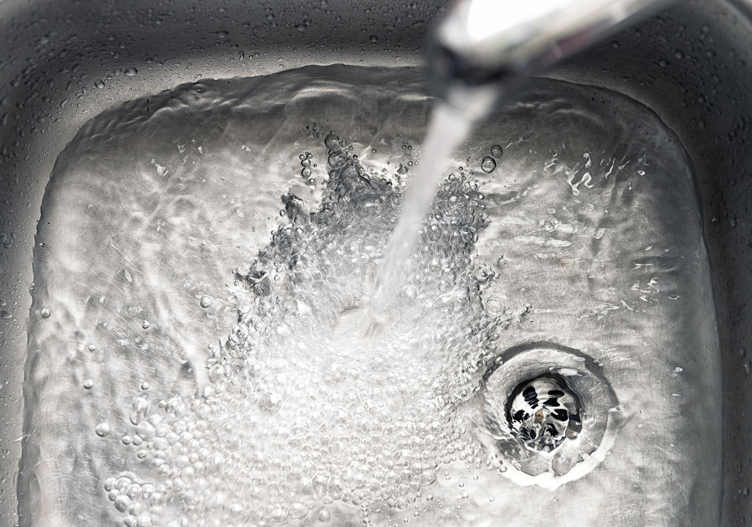 Water fills a stainless steel kitchen sink