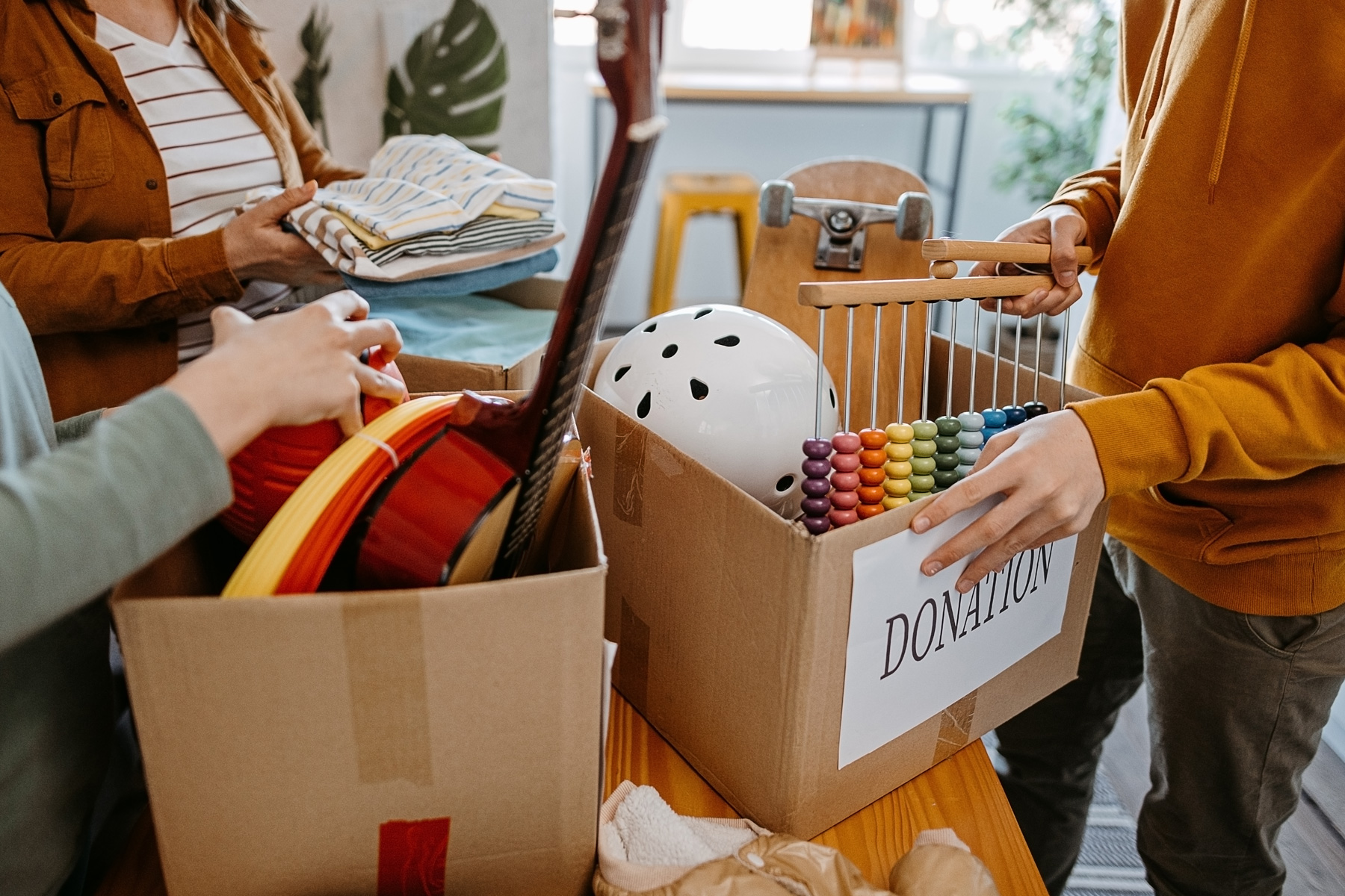 a family puts toys and clothes they don't need into boxes for donation