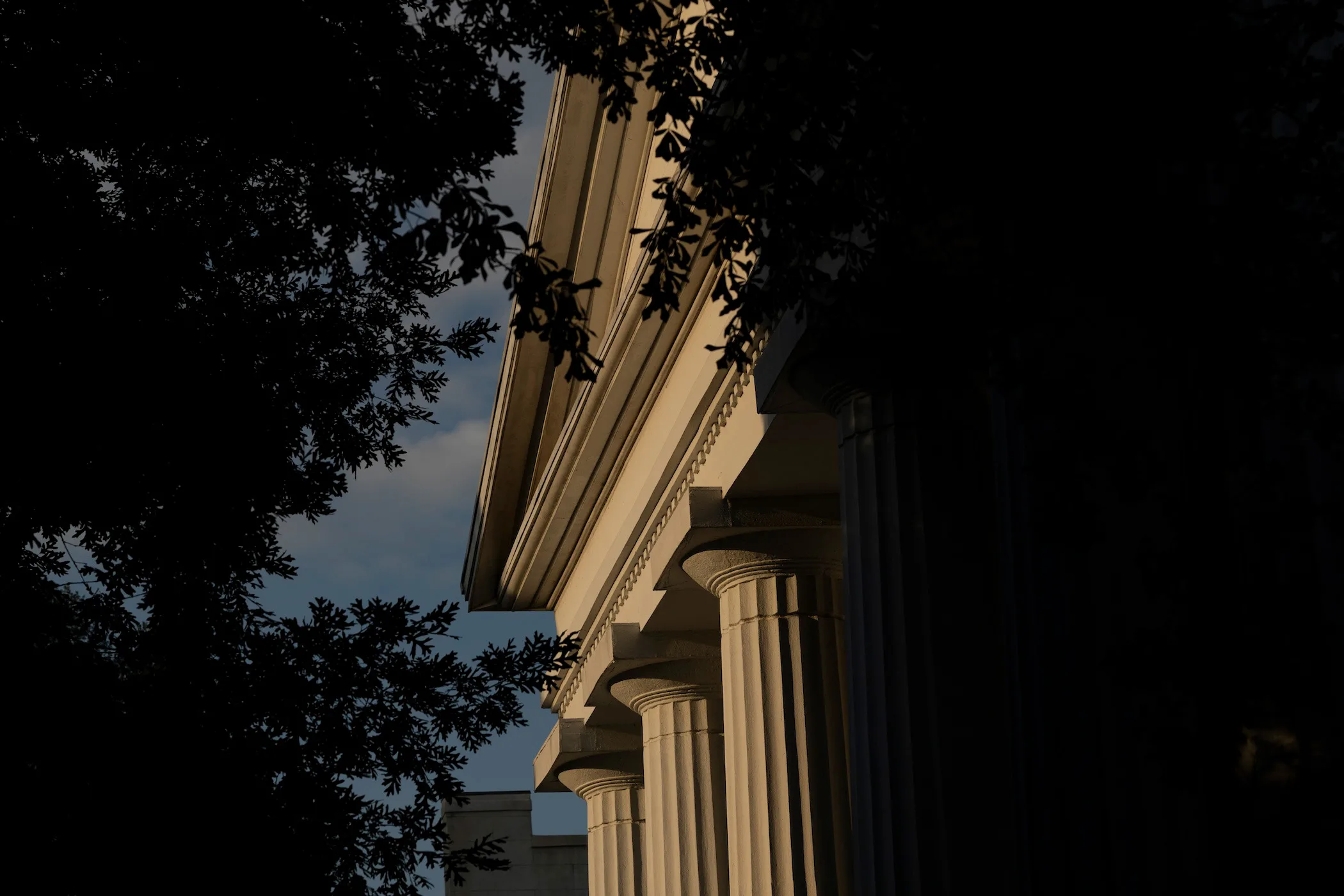 A view of a columned building on UGA's North Campus, framed by trees