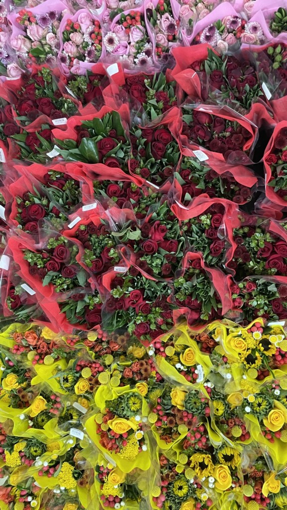 An image of dozens of boquets of multi-colored flowers taken from above.