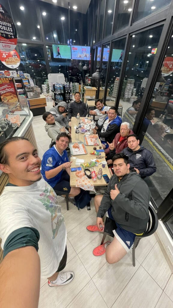 A selfie of a group of people eating at a casual restaurant.