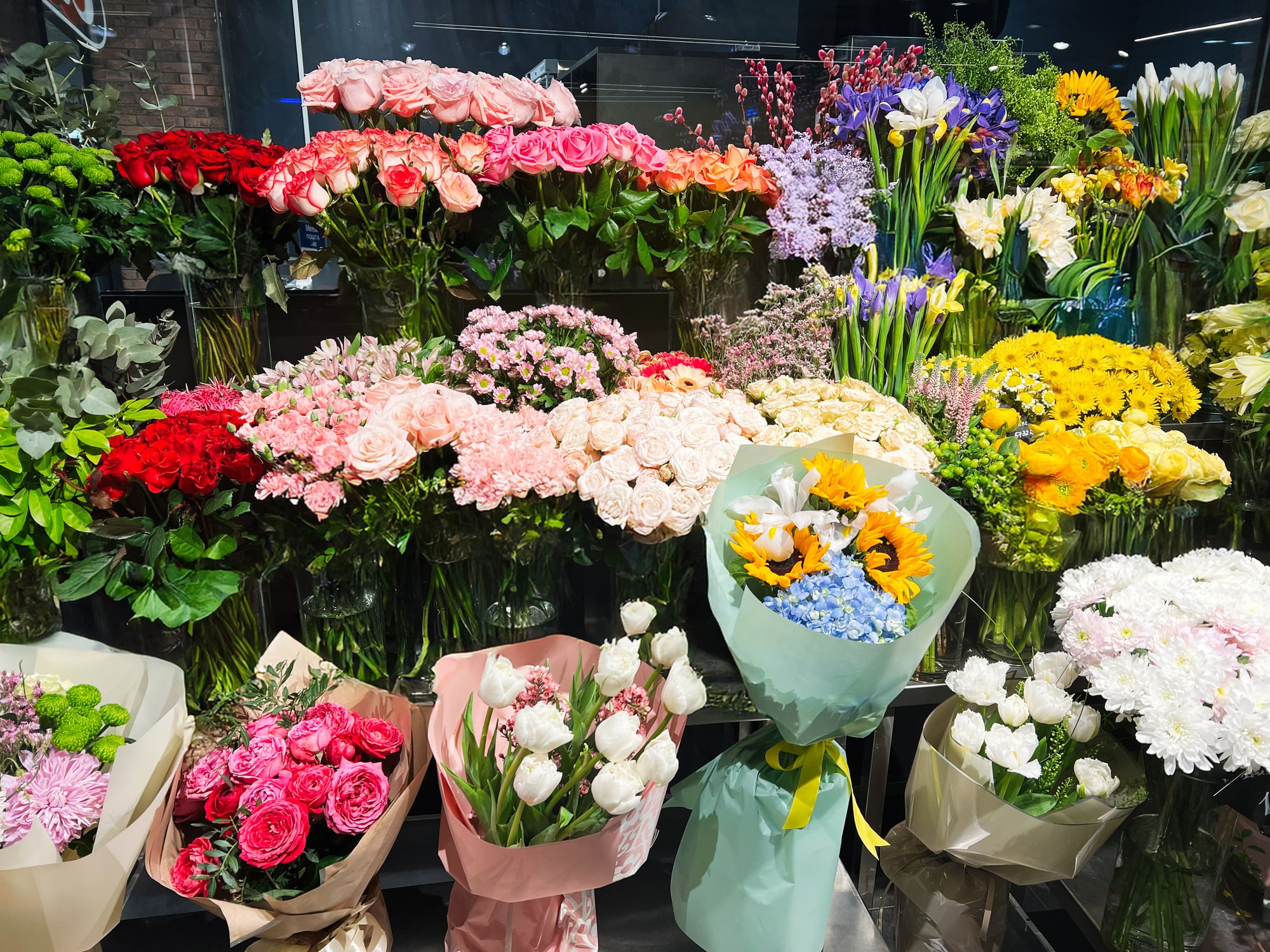 A colorful collection of flower bouquets arranged and displayed at a market.