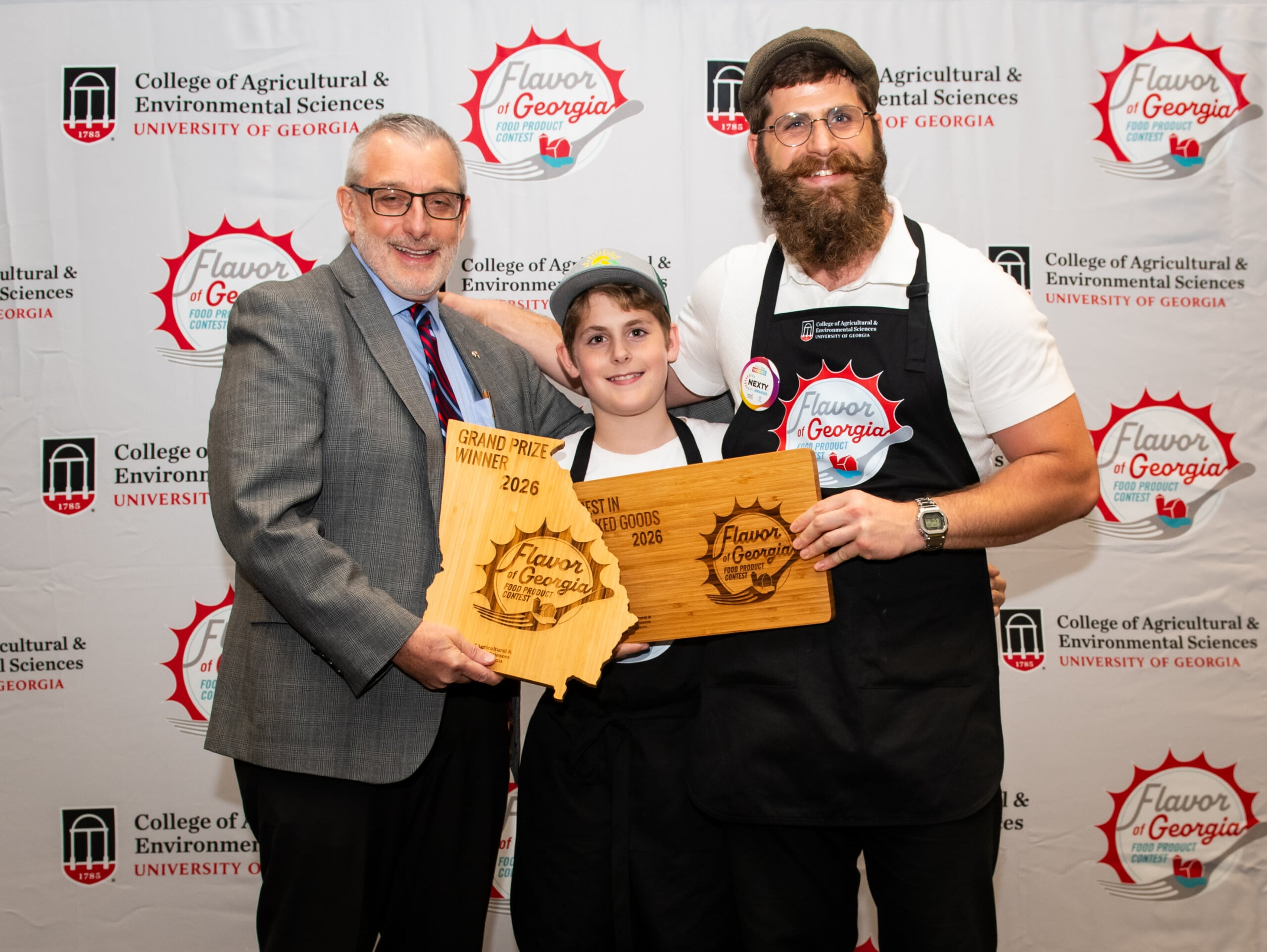 Papa Mountain won the grand prize at the 2026 Flavor of Georgia food product competition for its Garlic and Herb Bread Rolls. The winner and his son are pictured on stage with CAES Dean and Director Nick T. Place.