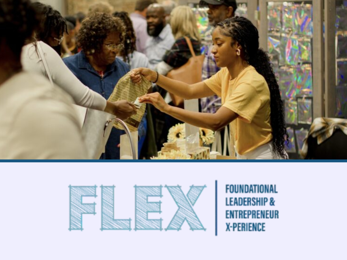A young woman at a vendor table hands a cloth item to an older woman in a crowded indoor market setting. The table is decorated with sunflowers and gift bags. Below the photo is the FLEX logo with the words ‘Foundational Leadership & Entrepreneur X‑perience.