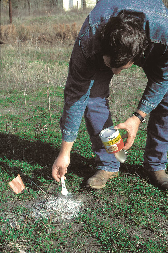 A man applies a powdered substance to a lawn