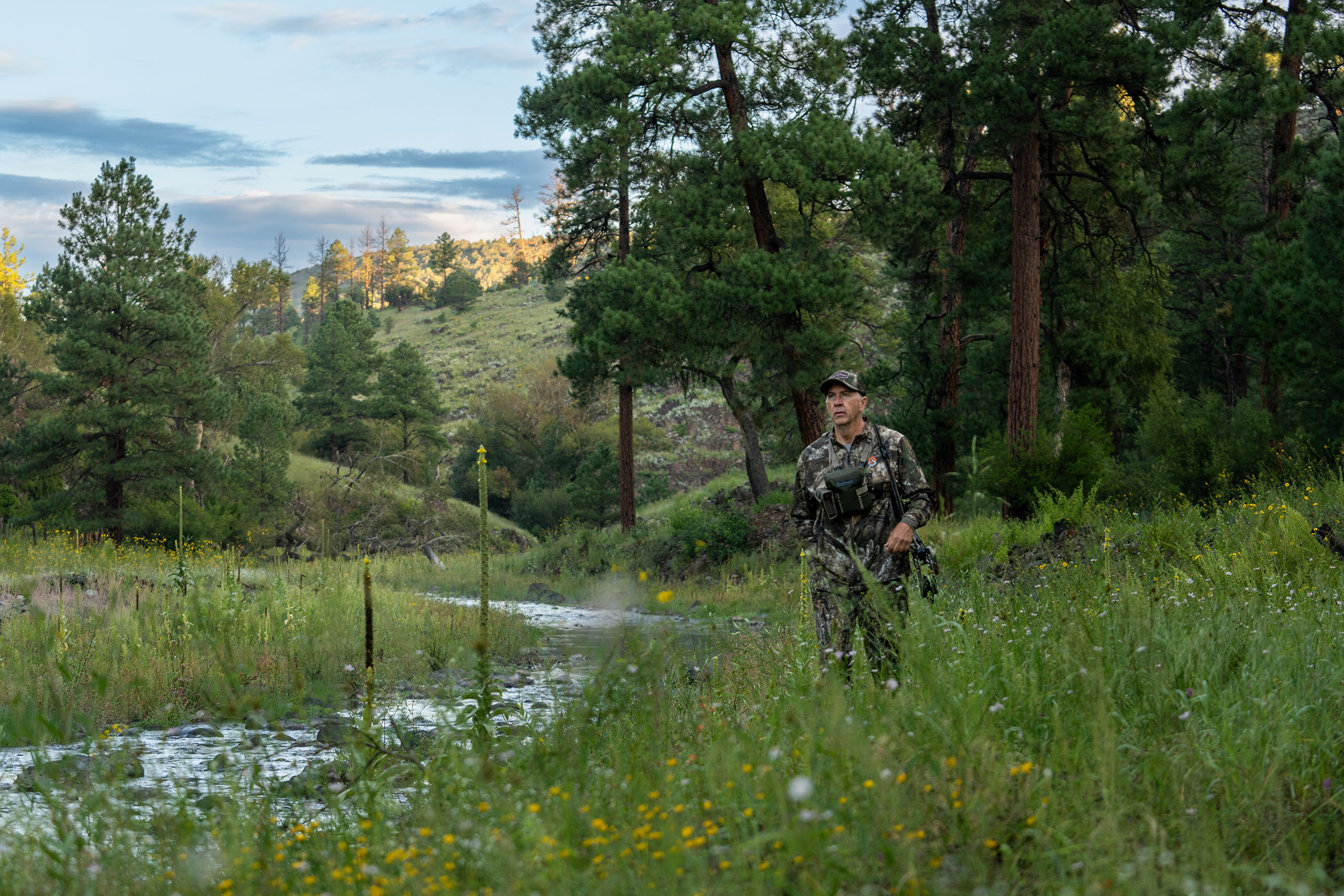 David Blanton walks next to a stream in scenic woods