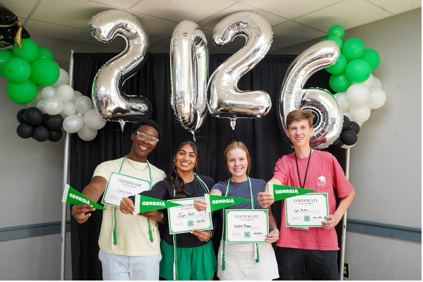 Georgia 4-H graduates pose with balloons and other decorations as they show off their certificates
