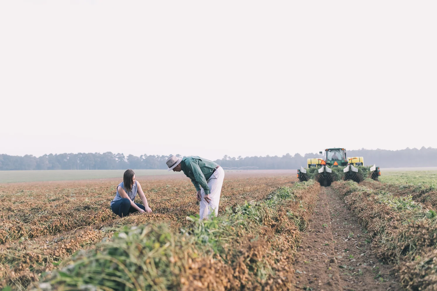 Casey Kerr and her father examine peanuts in a field