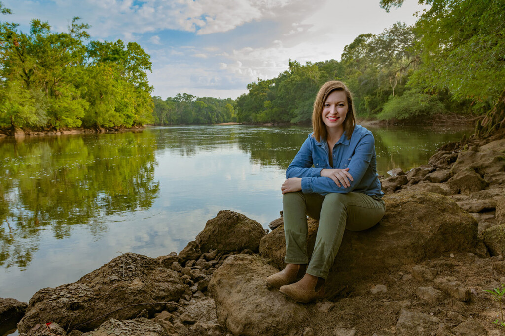 Casey Kerr sits on a river bank