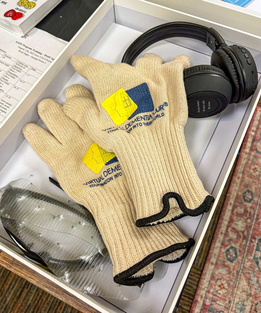 A box containing a pair of thick gloves, headphones and glasses