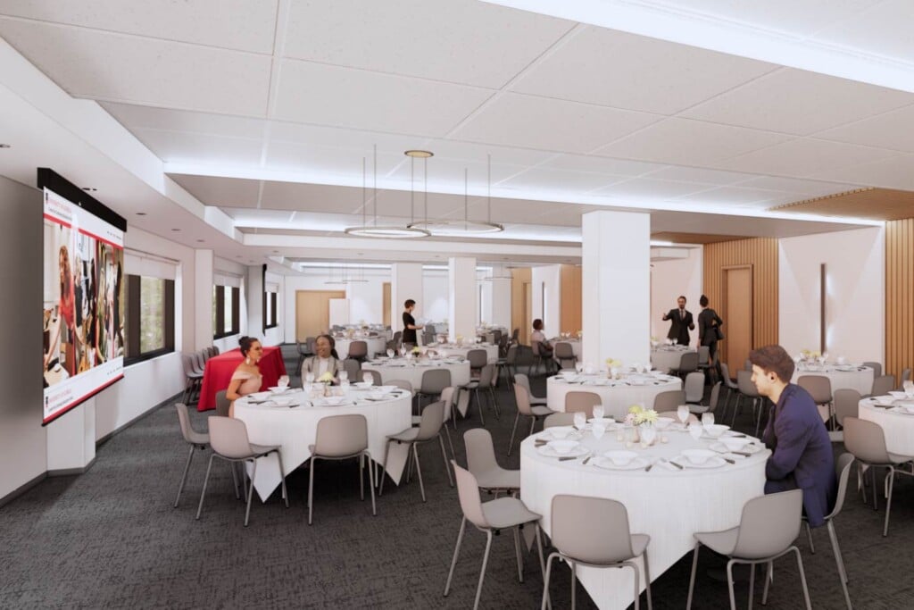Computer-generated rendering of a large, open room with several dining tables, windows and large projection screen