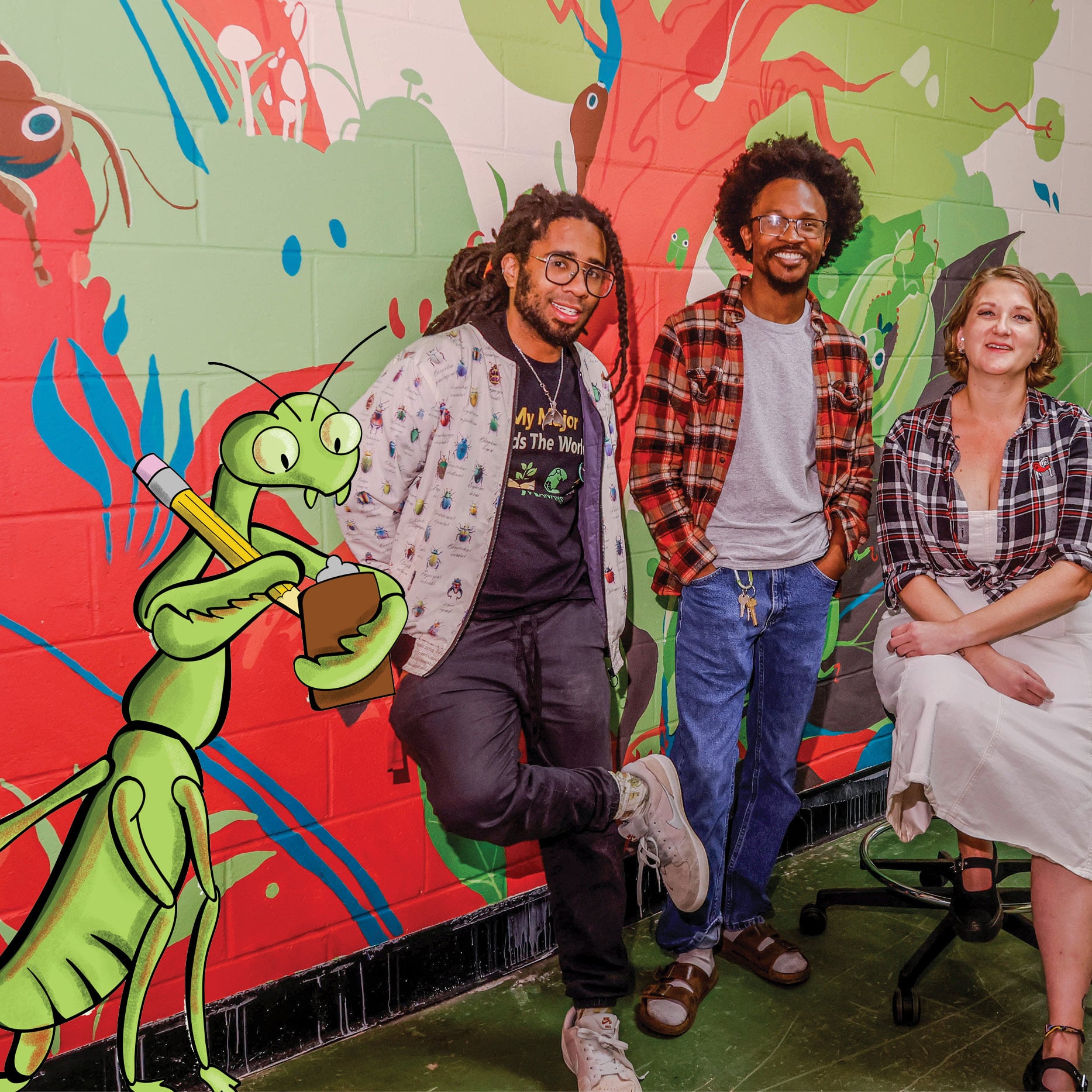 Three people in front of a mural and a cartoon praying mantis