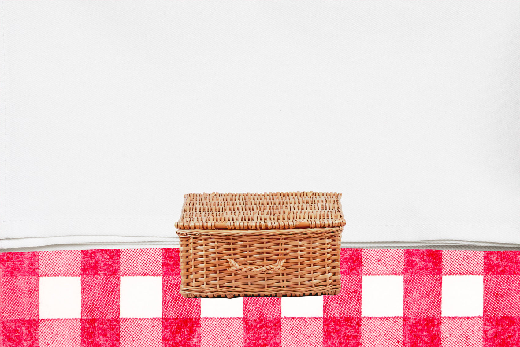 Closed picnic basket on tablecloth background