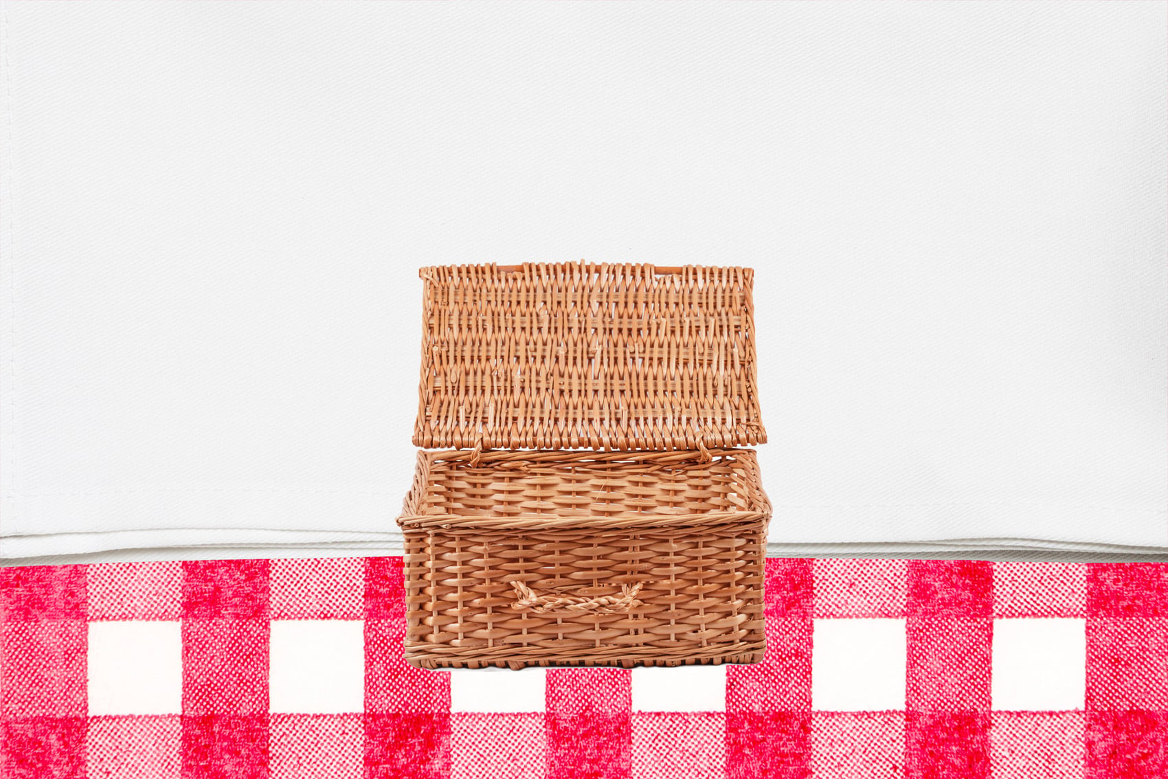 Open picnic basket on tablecloth background