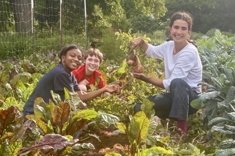 UGA alum Maya Alandete works with other students in a garden