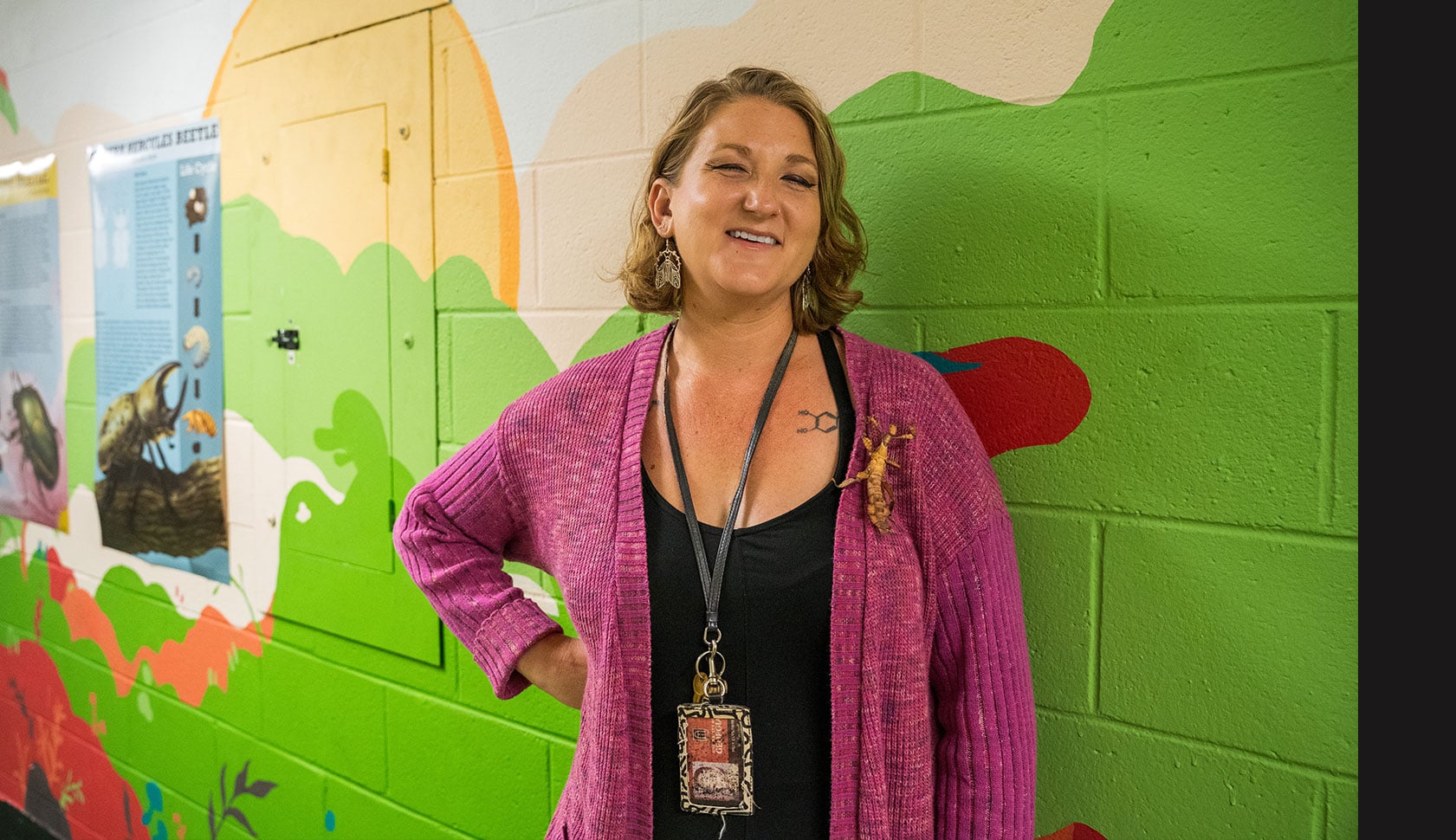 Kelly Carruthers stands in front of a mural at the UGA Insect Zoo
