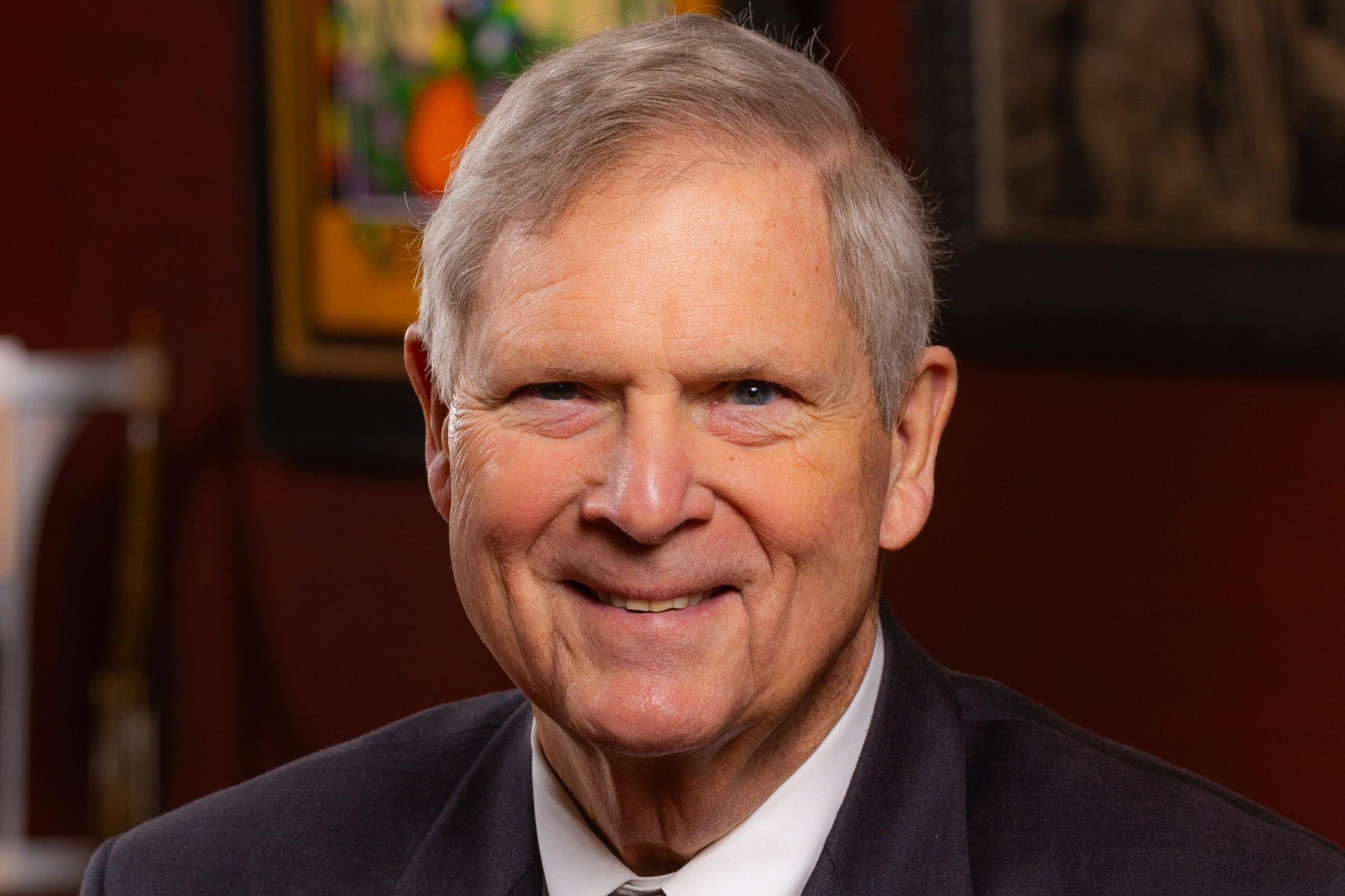 Thomas Vilsack smiles at the camera while wearing a suit and tie